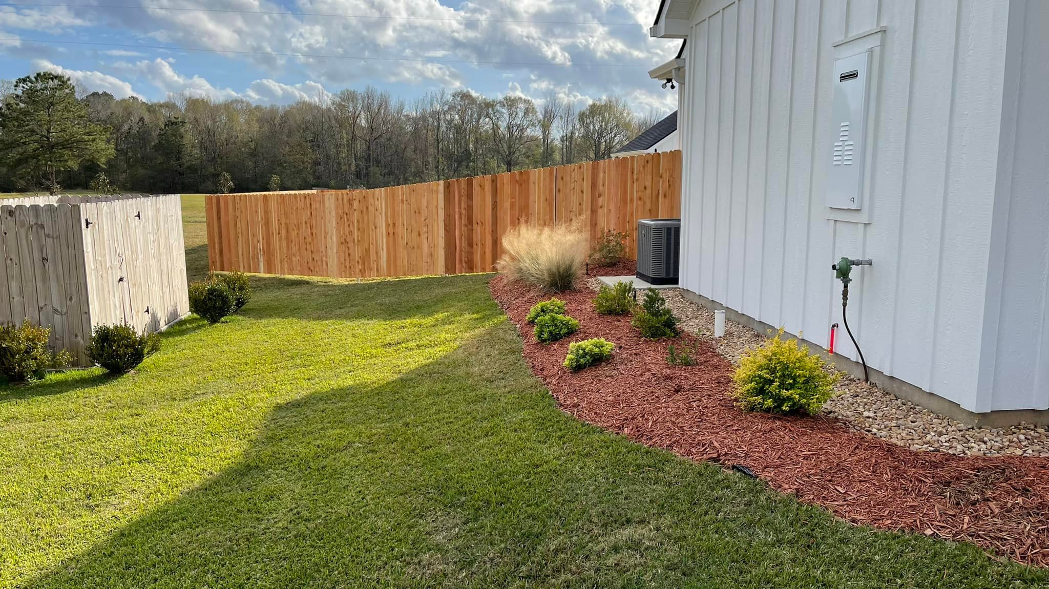 Cedar privacy fence along side yard with landscaping